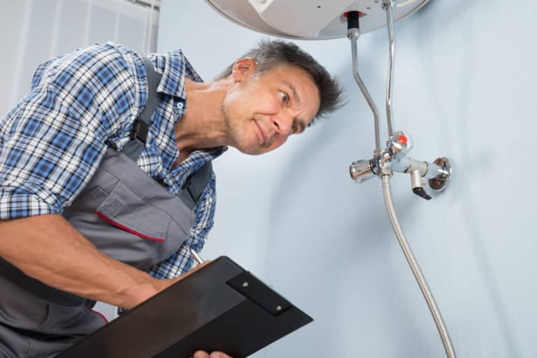 A repair man inspecting an electric boiler